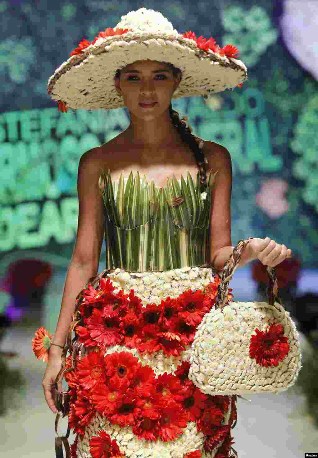 اس منفرد فیشن شو میں ایک ماڈل پھولوں کے لباس میں ملبوس کیٹ واک کرتے ہوئے۔