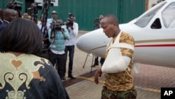 A Kenyan soldier, who Kenya Defence Forces said was injured in the attack by al-Shabab in Somalia, walks from an airplane to a waiting ambulance after being airlifted back to Nairobi for medical treatment, Jan. 17, 2016. 