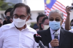Mantan Perdana Menteri Malaysia Mahathir Mohamad (kanan) dan anggota parlemen oposisi Anwar Ibrahim (kiri) berbicara kepada media saat mereka memprotes penutupan parlemen di Kuala Lumpur pada 2 Agustus 2021. (Foto: AFP/Arif Kartono)