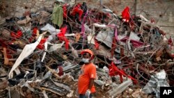 A Bangladeshi rescuer stands amid the rubble of a garment factory building that collapsed on April 24 as they continue searching for bodies in Savar, near Dhaka, Bangladesh, May 12, 2013.