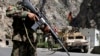 FILE - Afghan National Army soldiers stand guard along the main highway linking Kabul to Kandahar, outside the capital, Aug. 2013.