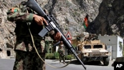 FILE - In this Aug. 27, 2013 photo, Afghan National Army soldiers stand guard on the outskirts of in Kabul, Afghanistan.