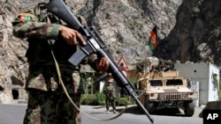 FILE - Afghan National Army soldiers stand guard along the main highway linking Kabul to Kandahar, outside the capital, Aug. 2013.