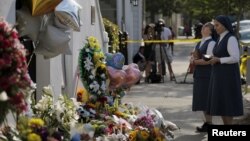 A man lights candles at a symbolic memorial outside Sennaya subway station in St. Petersburg, Russia. A bomb blast tore through a subway train, killing several people and wounding many more.