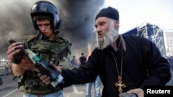 Protesters hold a petrol bomb during clashes with pro-government forces at Independence Square in Kyiv. Tensions flared on Thursday on Kyiv's Independence Square when protesters still camped there clashed with city workers who tried to clear away their tents.