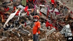 A Bangladeshi rescuer stands amid the rubble of a garment factory building that collapsed on April 24 as they continue searching for bodies in Savar, near Dhaka, Bangladesh, May 12, 2013.