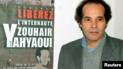 Le juge Mokhtar Yahyaoui pose devant une affiche publicitaire à Tunis le 7 février 2003, après une réunion tenue pour libérer son neveu, Zouhair Yahyaoui, qui a été arrêté en mai 2002.