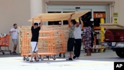 Customers buy plywood sheets to protect their homes at a Home Depot in Florida City, Fla., Sept. 8, 2017. Hurricane Irma weakened slightly Friday but remained a dangerous and deadly hurricane taking direct aim at Florida.