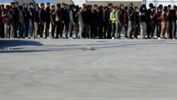 Migrants queue as they wait for their lunch in Roccella Jonica, Calabria region, southern Italy, Nov. 14, 2021.