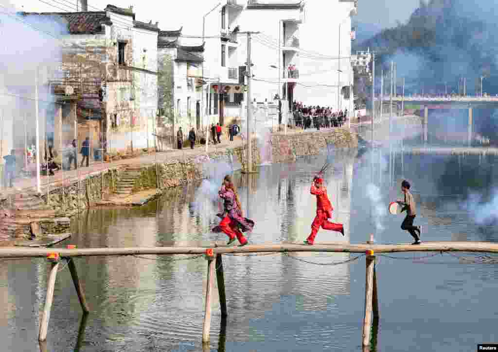 Seniman lokal menampilkan tarian tradisional Nuo pada hari kedua perayaan Tahun Baru Imlek (Tahun Babi) di sebuah desa di Wuyuan, provinsi Jiangxi, China.