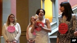 FILE - In this image taken from video, Fraidy Reiss, center, founder and executive director of Unchained at Last, a nonprofit organization that seeks to end child marriages, demonstrates in chains at the State Capitol in Albany, N.Y., Feb. 14, 2017. New York is one of seven states in which legislation similar to New Jersey's effort to ban child marriage has been introduced.