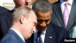 Russian President Vladimir Putin (L) walks past U.S. President Barack Obama (C) during a group photo at the G20 Summit in St. Petersburg September 6, 2013. 