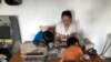 Une mère scolarise ses enfants à la maison en raison de la fermeture d'écoles due à la pandémie de COVID-19 dans le Queens, à New York, le 20 mars 2020.