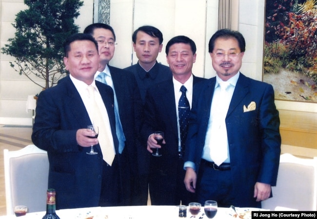 Ri Jong Ho, left, poses with Chinese investment tycoon Sam Pa, right, and others at a banquet hall in Pyongyang in January 2007.