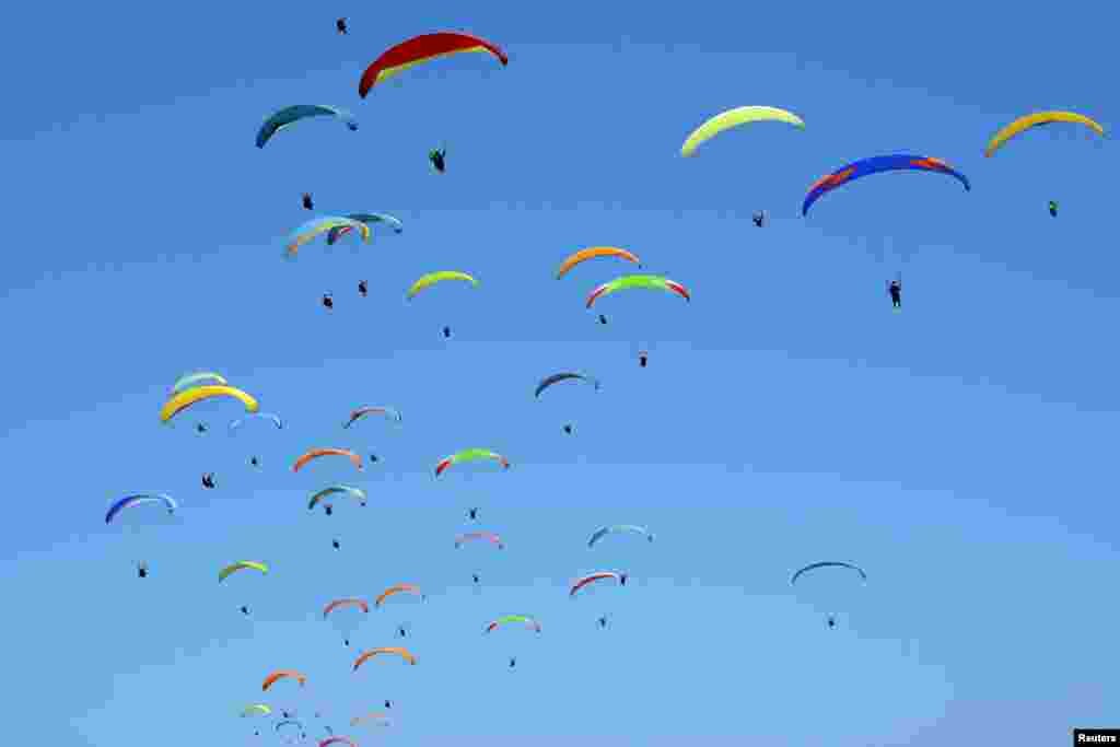 Paragliders fly in the sky attempting to break a record in Gunung Payung, Badung regency, Bali, Indonesia , in this photo taken by Antara Foto.