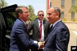 FILE - Visiting U.S. Defense Secretary Ash Carter, left, shakes hands with Iraqi Defense Minister Khaled al-Obeidi at the Ministry of Defense, Baghdad, Iraq, July 11, 2016.
