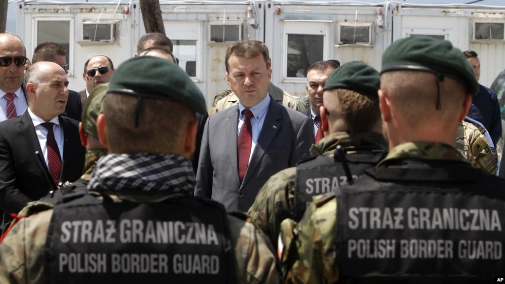 지난해 5월 마리우스 블라스자크 폴란드 내무장관(가운데)이 마케도니아 접경 지역에서 국경 검문 담당자들과 대화하고 있다. (자료사진)