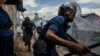 FILE - Burundi's policemen and army forces run after protesters against incumbent President Pierre Nkurunziza's bid for a third term in Bujumbura, May 13, 2015.