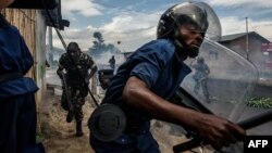 FILE - Burundi's policemen and army forces run after protesters against incumbent president Pierre Nkurunziza's bid for a 3rd term on May 13, 2015 in Bujumbura, May 13, 2015. Officials in Burundi say at least five people were killed and six injured when gunmen opened fire on a market Monday evening.