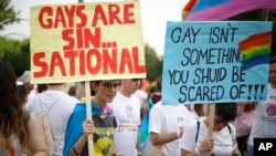 Participants hold signs during the annual Gay Pride parade in Jerusalem, June 6, 2019. 