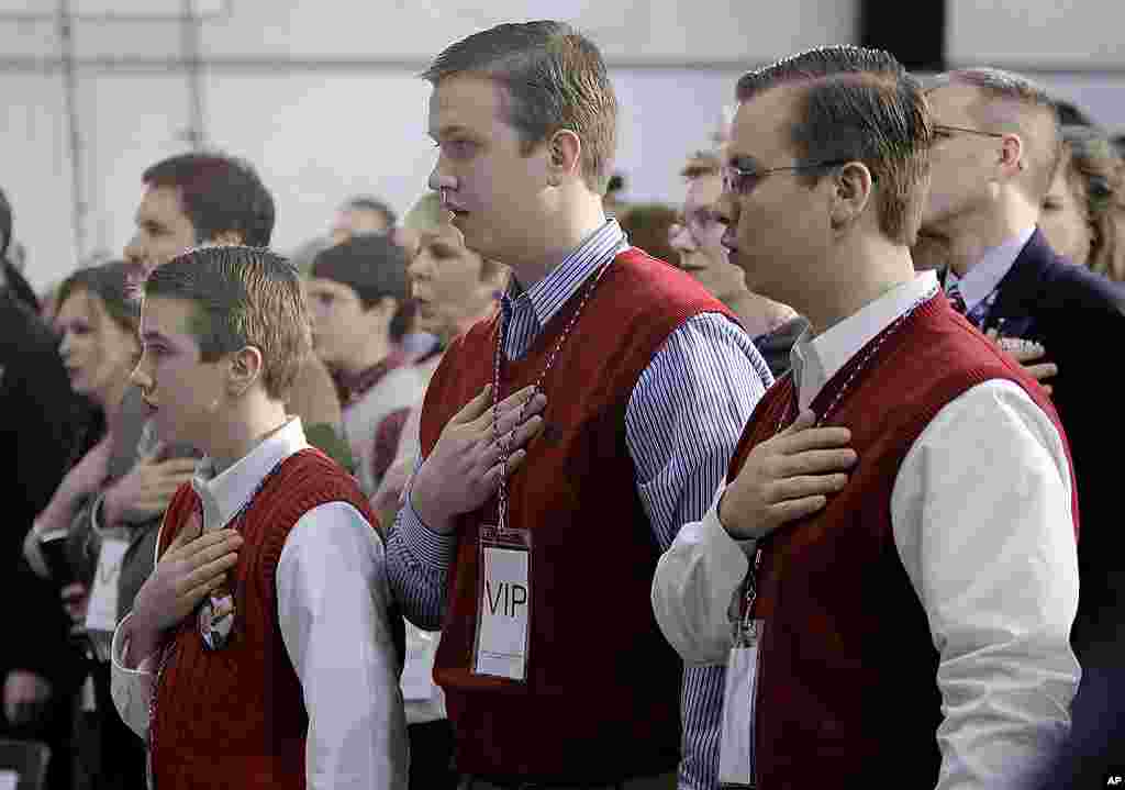 Brothers, from left, Laine, Logan and Luke Hicks, recite the Pledge of Allegiance before Republican presidential candidate Rick Santorum speaks at a Kalamazoo, Michigan rally on February 27, 2012. (AP)