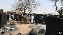 Le président du Mali, Ibrahim Boubacar Keita, inspecte les dégâts après une attaque par des hommes armés contre des éleveurs peuls à Ogossagou, au Mali, le 25 mars 2019.