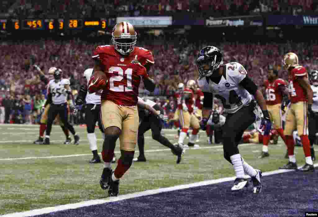 San Francisco 49ers running back Frank Gore (21) scores a third quarter touchdown against Baltimore Ravens cornerback Corey Graham (24) in the NFL Super Bowl XLVII football game in New Orleans, Louisiana, February 3, 2013.