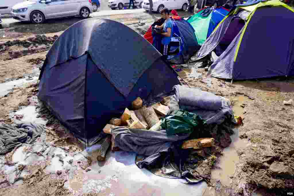 Wood stocked outside a tent in the camp, March 9, 2016. (J. Dettmer/VOA)