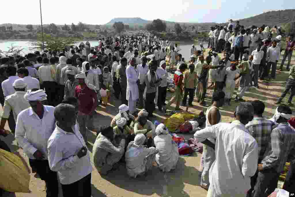 Villagers gather after a deadly stampede on a bridge across the Sindh River in Datia district in Madhya Pradesh state, India, Oct. 13, 2013.