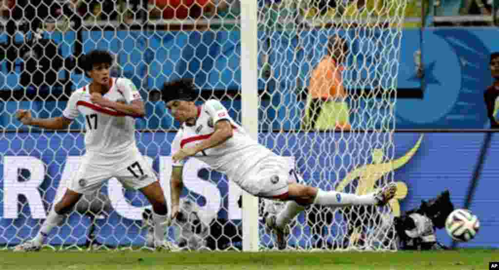 Costa Rica's Christian Bolanos kicks the ball in defense next to Costa Rica's Yeltsin Tejeda (17) during the World Cup quarterfinal soccer match between the Netherlands and Costa Rica at the Arena Fonte Nova in Salvador, Brazil, Saturday, July 5, 2014. (A