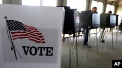 FILE - Voters cast their ballots in Hinsdale, Ill., March 18, 2014.