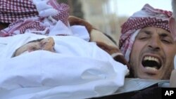 A man chants anti-government slogans while carrying the body of Abdulaziz Abu Ahmed Khrer, killed by a Syrian Army sniper, during his funeral in Idlib, north Syria, March 8, 2012