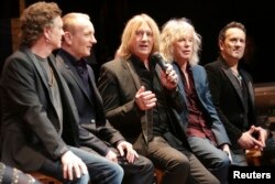 FILE - Rick Allen (L-R), Phil Collen, Joe Elliott, Rick Savage and Vivian Campbell of Def Leppard speak on stage at the House of Blues in West Hollywood, California, March 17, 2014.