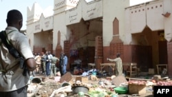 Soldiers and police forces stand guard at a market in N'Djamena, Chad, following a suicide bomb attack, July 11, 2015. 