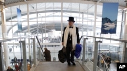 A passenger in evening dress hurries as he goes to check in for the MS Balmoral Titanic memorial cruise in Southampton, England, Sunday, April 8, 2012.