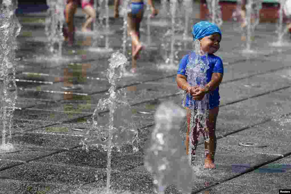 루마니아 남부 지역이 섭씨 37도의 고온을 기록한 가운데, 부쿠레슈티 공원 분수대에서 한 어린이가 물놀이를 하고 있다.