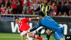 Benfica's Enzo Perez, left, from Argentina, challenges Fenerbahce's goalkeeper Volkan Demirel, right, and Cristian, from Brazil, during their Europa League semi final second leg soccer match in Lisbon, Thursday, May 2, 2013.