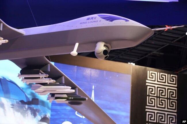 A model of a Wing Loong II weaponized drone hangs above the stand for the China National Aero-Technology Import & Export Corp. at a military drone conference in Abu Dhabi, United Arab Emirates, Feb. 25, 2018.