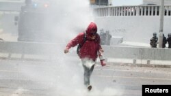 Un manifestante en Tegucigalpa, Honduras, es golpeado por un cañón de agua de la policía durante una protesta contra los planes del gobierno para privatizar la salud y la educación. Mayo 30 de 2019. REUTERS/Jorge Cabrera.