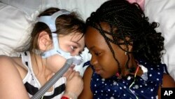 Sarah Murnaghan, left, lies in her hospital bed next to adopted sister Ella on the 100th day of her stay in Children's Hospital of Philadelphia, (File photo).