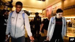 Los basquetbolistas de UCLA Cody Riley (izquierda), LiAngelo Ball (derecha) y Jalen Hill (centro atrás), son rodeados por la prensa a su llegada al Aeropuerto Internacional de Los Angeles el martes, 14 de noviembre de 2017.