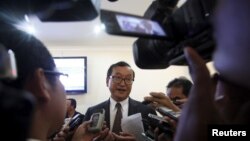 Sam Rainsy (C), president of the Cambodia National Rescue Party (CNRP), speaks to media after a plenary session at the National Assembly in Phnom Penh, March 19, 2015.