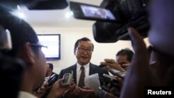 Sam Rainsy (C), president of the Cambodia National Rescue Party (CNRP), speaks to media after a plenary session at the National Assembly in Phnom Penh, March 19, 2015.