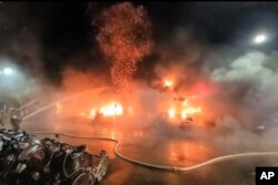 In this image taken from video by Taiwan's EBC, firefighters battle a blaze at a building in Kaohsiung, in southern Taiwan, Oct. 14, 2021.