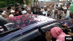 Para pendukung Malik Ishaq mengerumuni mobil yang membawa tokoh laskar-e-Jhangvi Muslim Sunni pasca-dibebaskan dari penjara Lahore (14/7). Malik Ishaq ditangkap kembali September lalu.