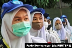 Siswa terlihat mengenakan masker pelindung wajah setelah pemerintah Indonesia membuka kembali sekolah dengan menerapkan proses pembelajaran tatap muka di tengah wabah Covid-19 di Bekasi, di pinggiran Jakarta, 13 Juli 2020. (Foto: Antara/Fakhri Hermansyah/