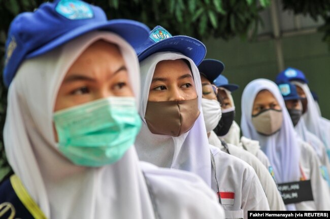 Siswa terlihat mengenakan masker pelindung wajah setelah pemerintah Indonesia membuka kembali sekolah dengan menerapkan proses pembelajaran tatap muka di tengah wabah Covid-19 di Bekasi, di pinggiran Jakarta, 13 Juli 2020. (Foto: Antara/Fakhri Hermansyah/