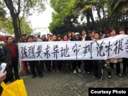 律师王宇和活动人士拉横幅要求异地审判范木根。(照片来源：现场活动人士)