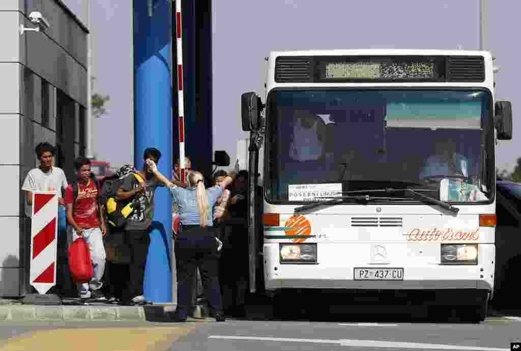 Croatian police officers take control the bus at the Batina border crossing with Serbia, that would take migrants to the center for asylum seekers, near Batina, Croatia.