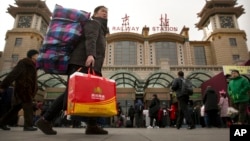 2018年2月9日，一名婦女在北京火車站外攜帶行李箱。中國國家統計局將此次製造業採購經理人指數下降歸因於春節假期外出務工人員返鄉。